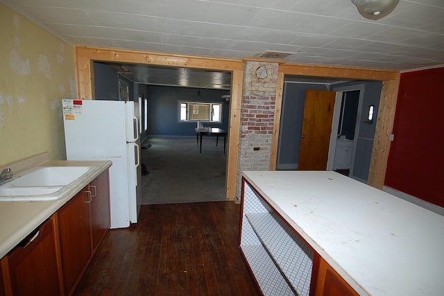 kitchen featuring white fridge, sink, and dark wood-type flooring