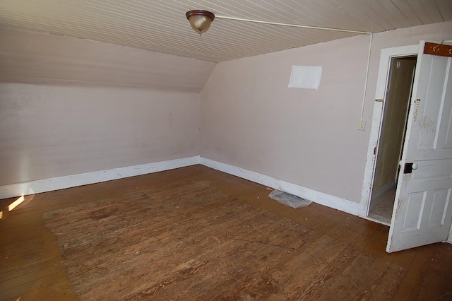 bonus room with dark wood-type flooring and vaulted ceiling