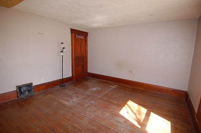 unfurnished room featuring hardwood / wood-style floors and a textured ceiling