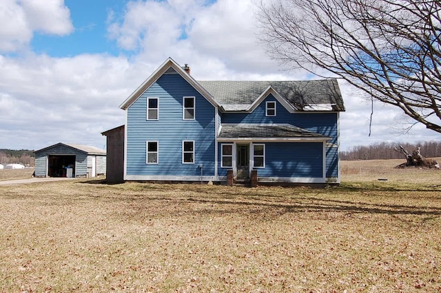 view of front of house with an outbuilding and a front yard