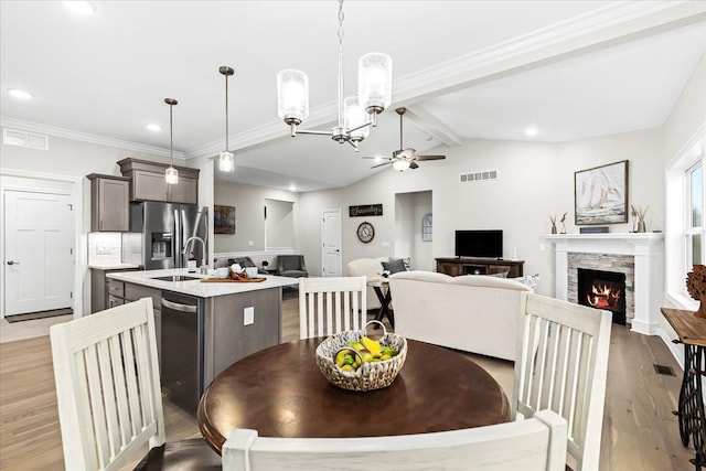 362 Jubilee Dr, Whitmore Lake, MI 48189 - dining room with a ceiling fan, light wood-type flooring, a stone fireplace, recessed lighting, and a chandelier