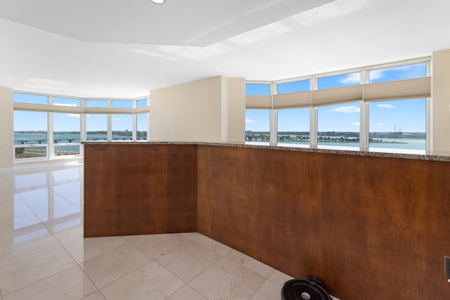 kitchen featuring plenty of natural light, a water view, and stone countertops