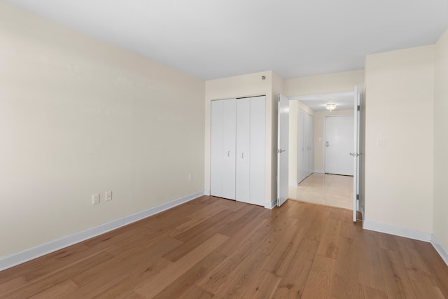 unfurnished bedroom featuring light wood-type flooring and a closet