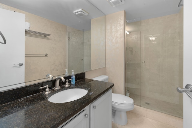 bathroom featuring tile patterned flooring, vanity, toilet, and a shower with shower door