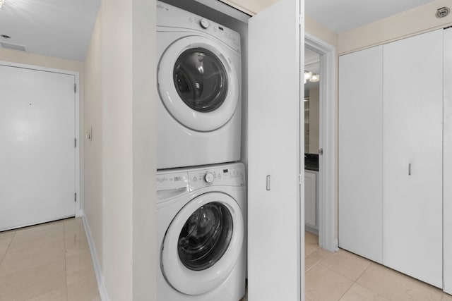 washroom with light tile patterned floors and stacked washer / dryer