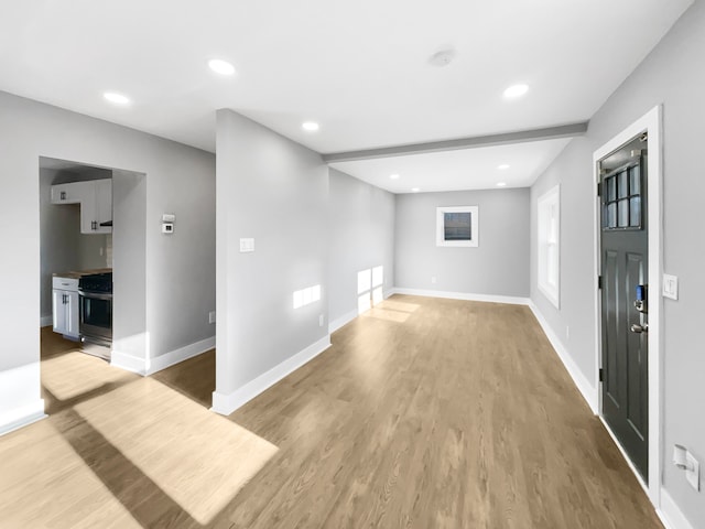 empty room with beamed ceiling and hardwood / wood-style floors