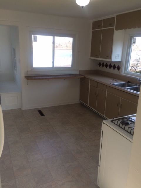 kitchen featuring white range with gas cooktop and sink