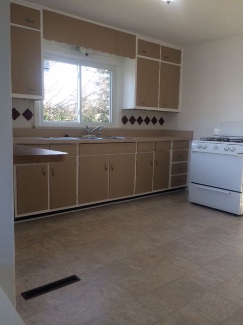 kitchen featuring sink and white range