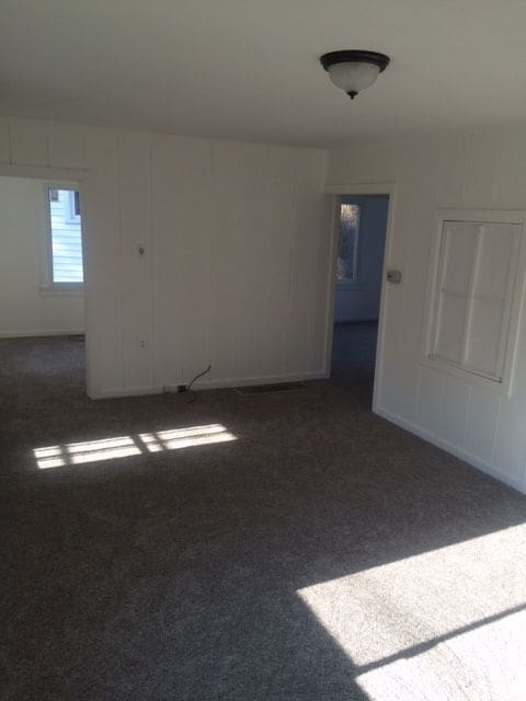 empty room with dark colored carpet