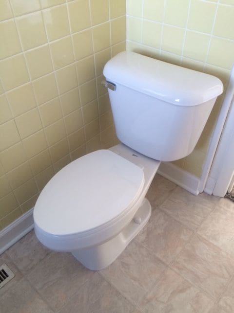 bathroom with tile patterned flooring, tile walls, and toilet