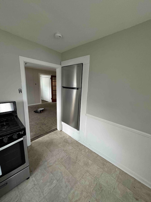 kitchen featuring light carpet and stainless steel appliances