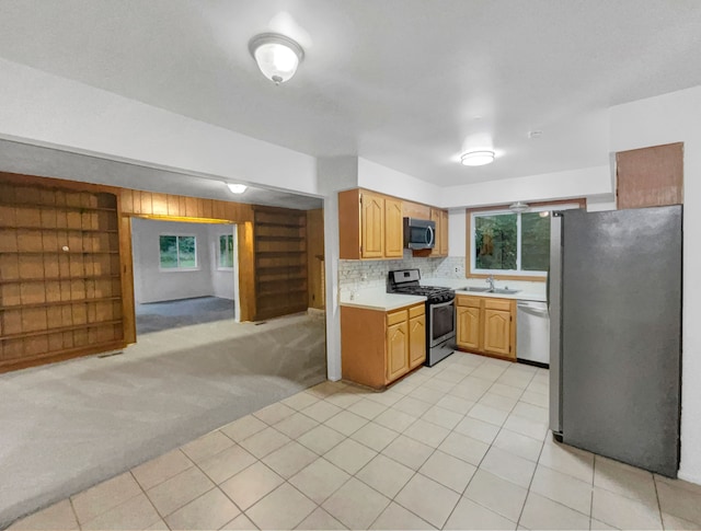 kitchen featuring backsplash, light carpet, sink, and stainless steel appliances