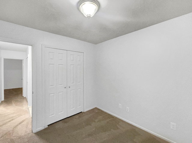 unfurnished bedroom featuring carpet flooring and a closet