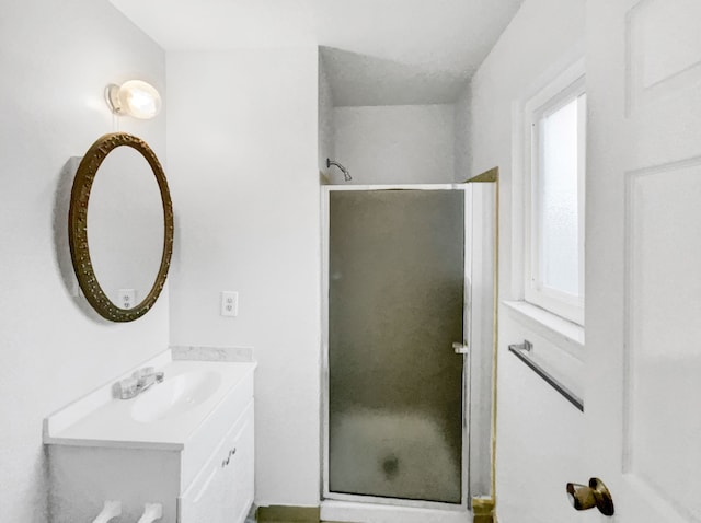 bathroom featuring vanity and a shower with door