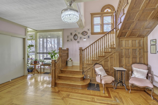 stairs featuring parquet flooring and a notable chandelier