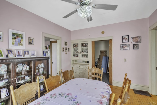 dining area featuring wood-type flooring and ceiling fan