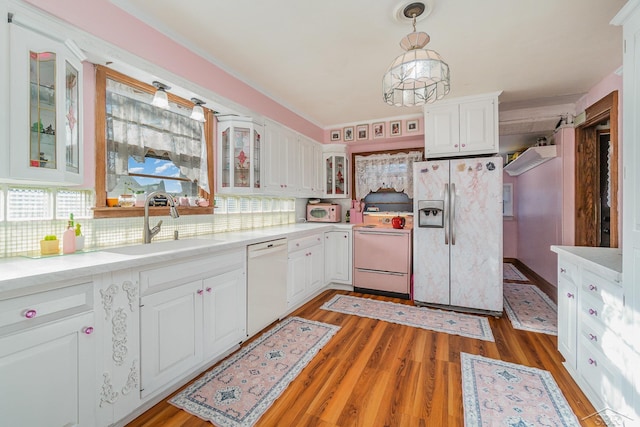 kitchen with white cabinets, pendant lighting, white appliances, and decorative backsplash