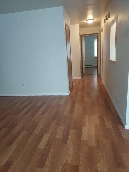 corridor with dark hardwood / wood-style flooring