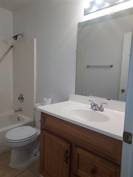 full bathroom featuring tile patterned floors, vanity,  shower combination, and toilet