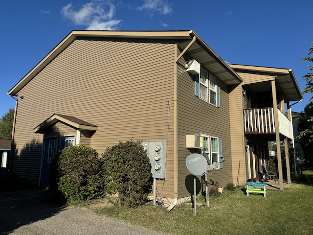 view of property exterior with a lawn and a balcony