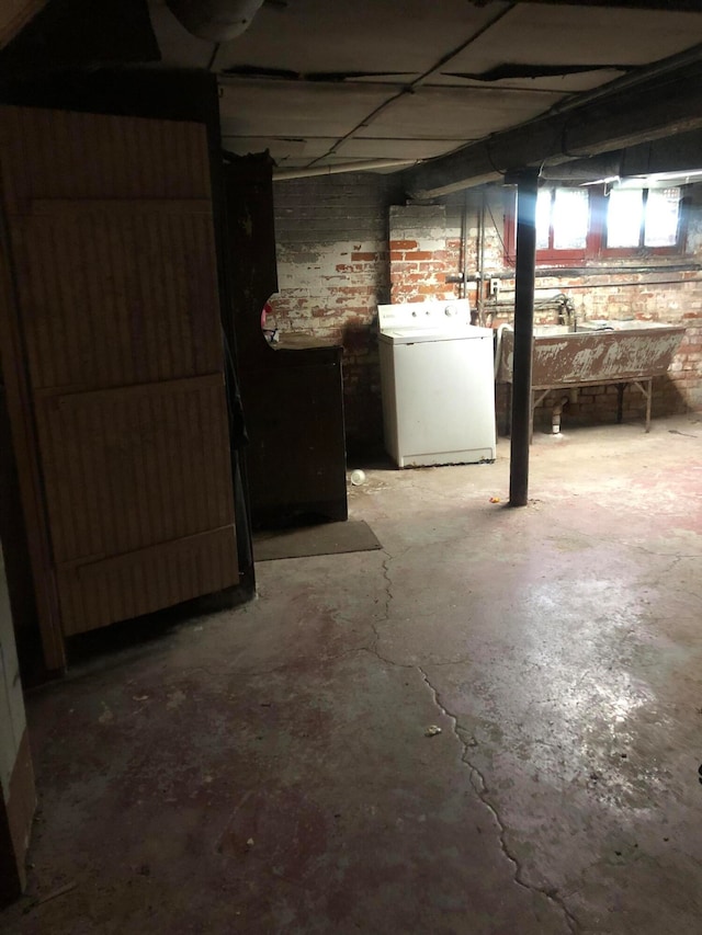 basement with washer / dryer and brick wall