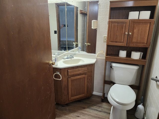 bathroom featuring hardwood / wood-style flooring, vanity, toilet, and tile walls