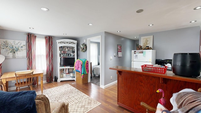 kitchen with hardwood / wood-style flooring, a breakfast bar, and white fridge