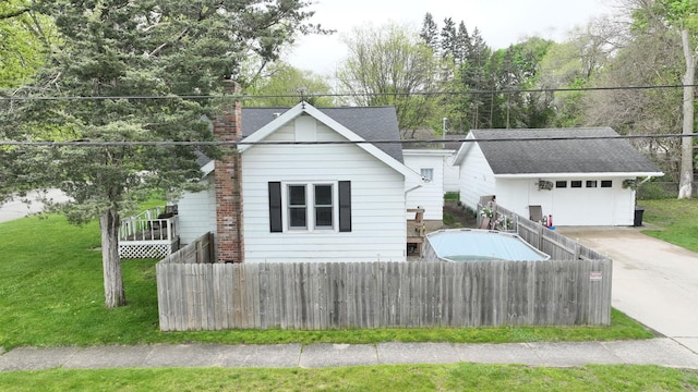 view of front of home featuring a garage, a front lawn, and an outdoor structure