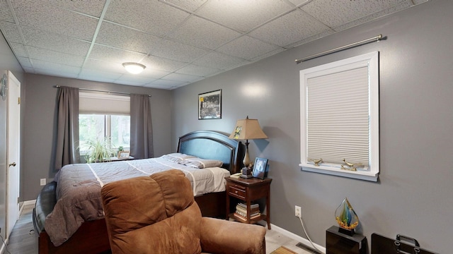 bedroom featuring a paneled ceiling and hardwood / wood-style floors