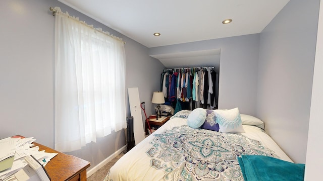 carpeted bedroom featuring a closet and multiple windows