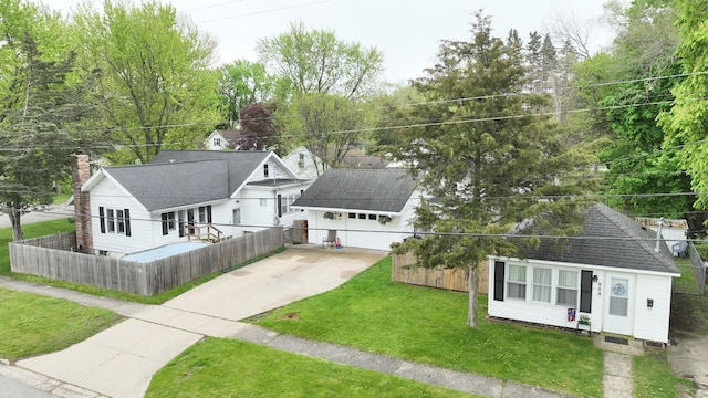 view of front of property with a garage, an outdoor structure, and a front lawn