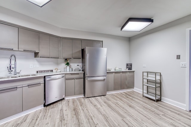 5000 Town Ctr Unit 2205, Southfield, MI 48075 - kitchen featuring stainless steel appliances, light wood-style flooring, a sink, light countertops, and gray cabinetry