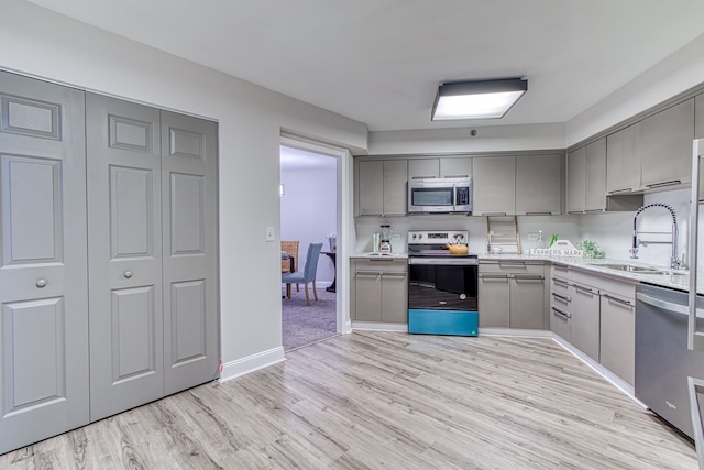 5000 Town Ctr Unit 2205, Southfield, MI 48075 - kitchen featuring stainless steel appliances, gray cabinets, a sink, and light wood-type flooring