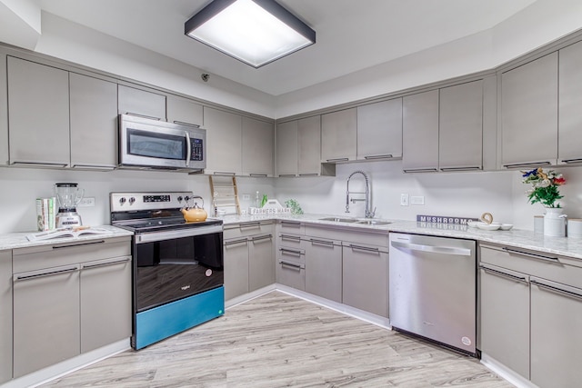 5000 Town Ctr Unit 2205, Southfield, MI 48075 - kitchen with stainless steel appliances, gray cabinetry, a sink, and light wood-style floors