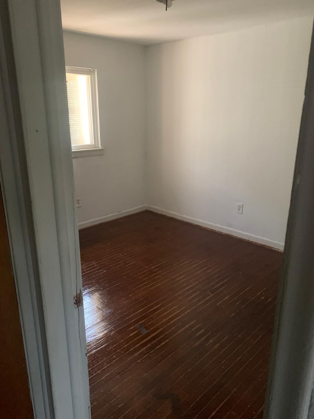 unfurnished room featuring dark wood-type flooring