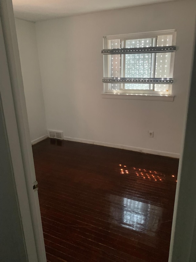 unfurnished room featuring dark wood-type flooring