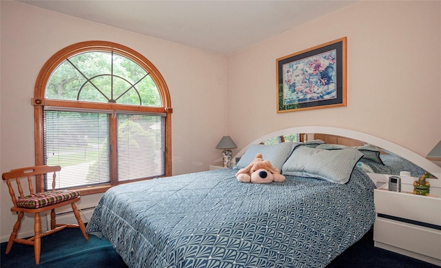 bedroom with carpet flooring and a baseboard heating unit