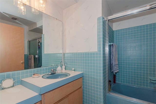 bathroom featuring vanity, tile walls, and enclosed tub / shower combo