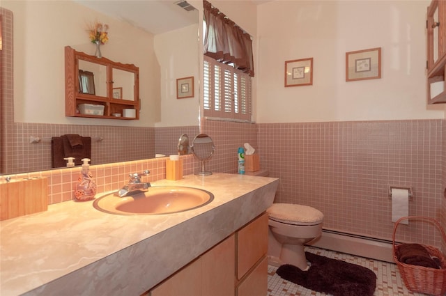 bathroom with tile patterned floors, vanity, baseboard heating, tile walls, and toilet