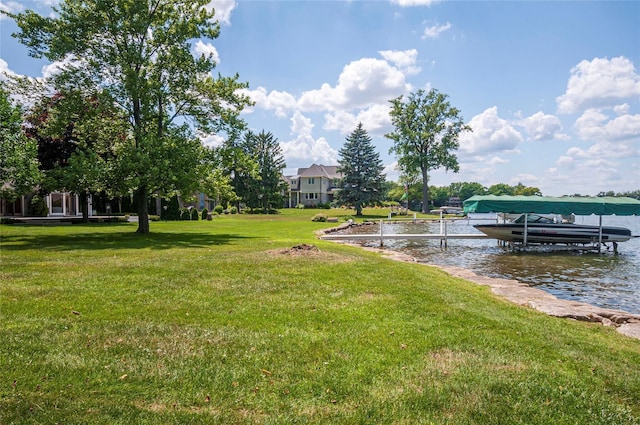 view of dock with a lawn and a water view