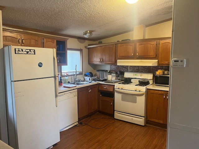 kitchen with lofted ceiling, white appliances, sink, a textured ceiling, and dark hardwood / wood-style flooring