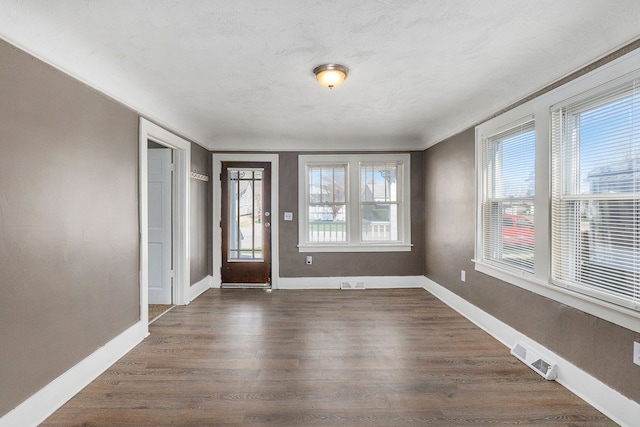 entrance foyer with dark wood-type flooring and a textured ceiling