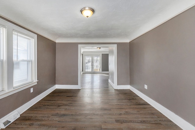 interior space with dark hardwood / wood-style floors, a healthy amount of sunlight, crown molding, and french doors