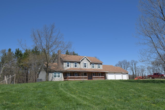 view of front of house featuring covered porch, a garage, and a front lawn