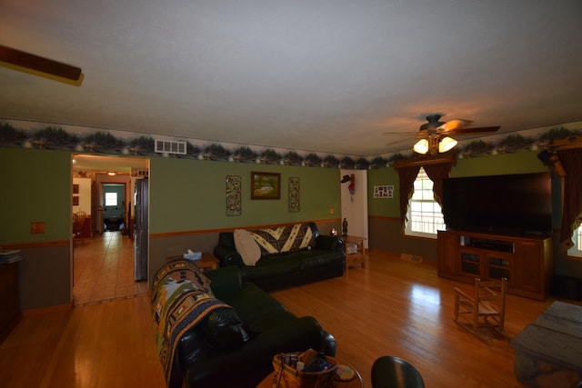 living room featuring ceiling fan and light hardwood / wood-style floors