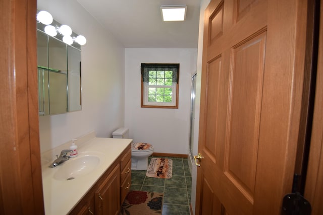 bathroom with toilet, a shower with door, vanity, and tile patterned flooring