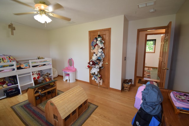 recreation room with ceiling fan and light hardwood / wood-style flooring