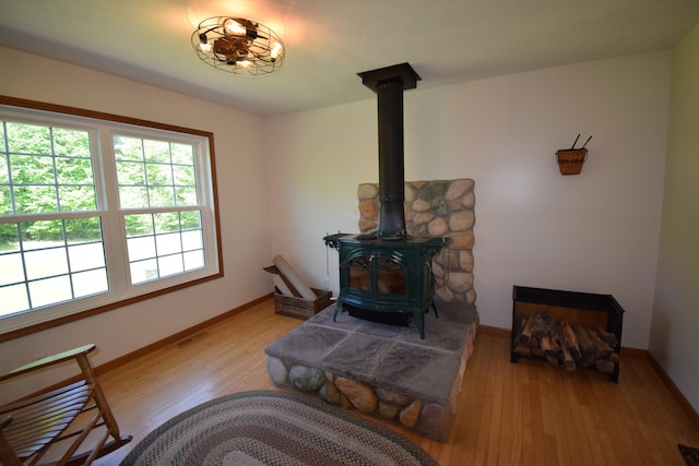 living room with a wood stove and light wood-type flooring