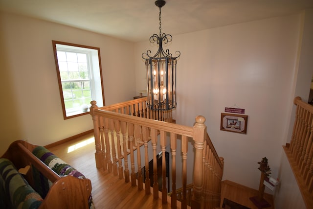 stairway with a chandelier and hardwood / wood-style flooring