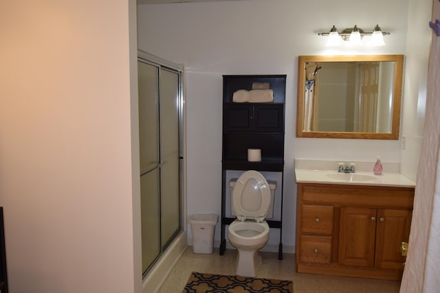 bathroom featuring vanity, toilet, and an enclosed shower